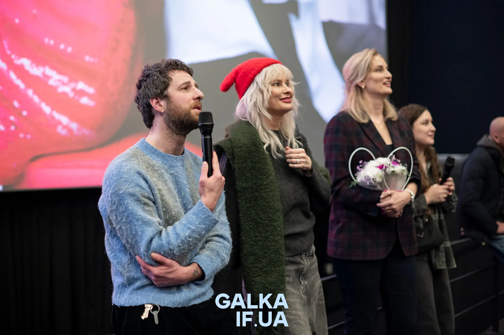 Люди виступають на сцені з мікрофонами