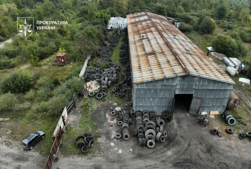 Старий ангар із купами використаних шин