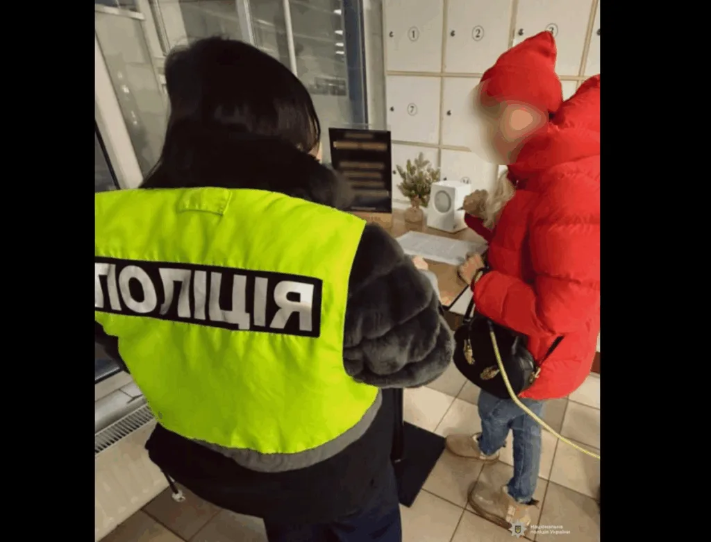 Поліцейський спілкується з жінкою у червоній куртці