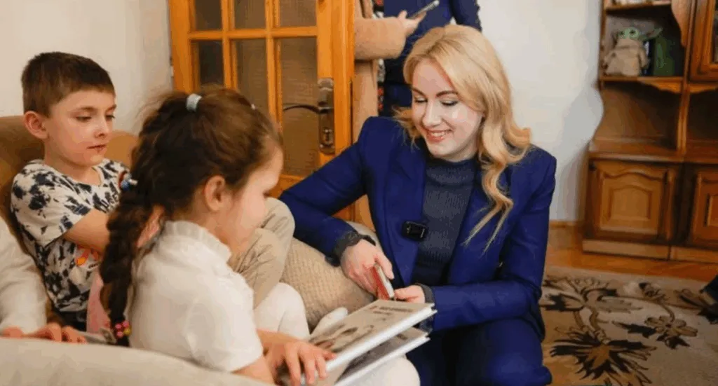 Жінка читає книгу дітям удома