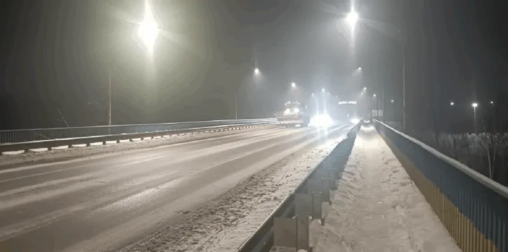 Нічний засніжений міст з освітленням