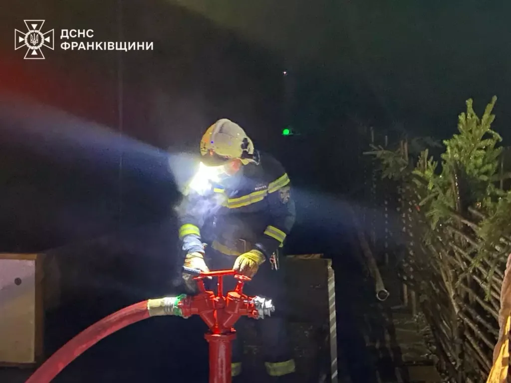 Пожежник працює з пожежним гідрантом уночі