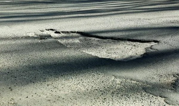 Велика вибоїна на асфальтованій дорозі