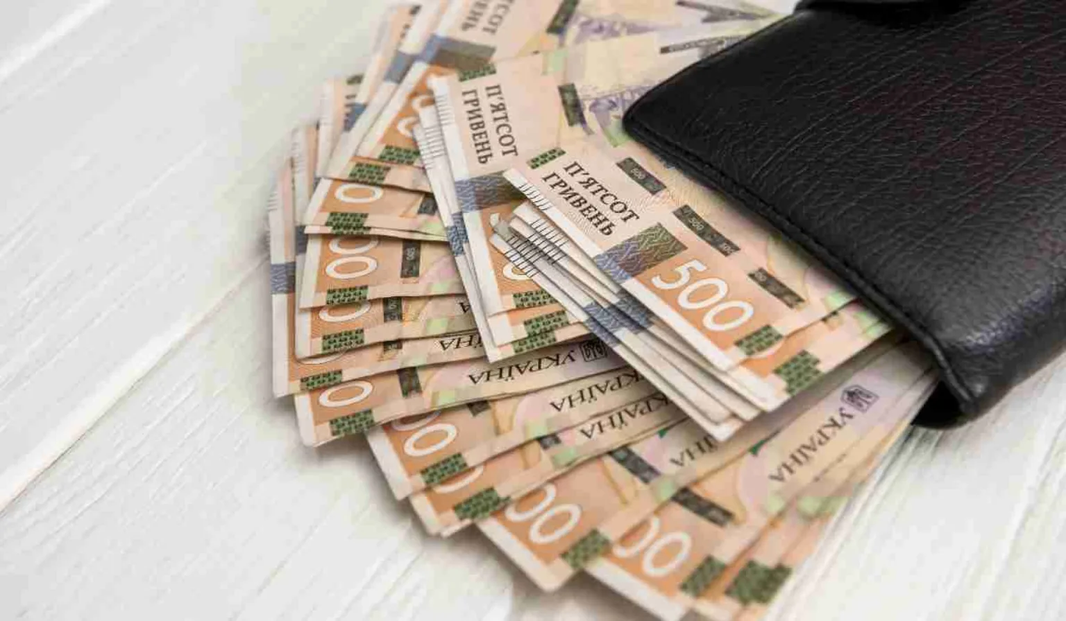 Пачка п’ятисот гривень у чорному гаманці