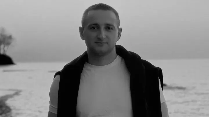 Чоловік стоїть на узбережжі моря взимку