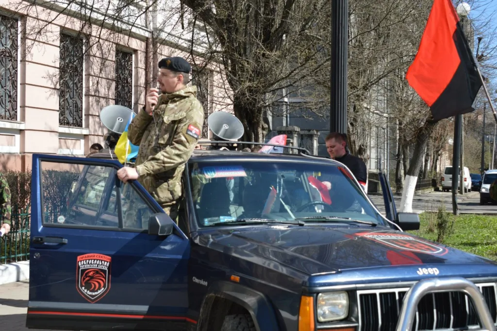 Військові біля автомобіля з прапорами на вулиці