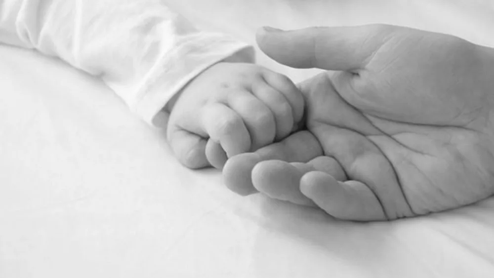 Дитяча рука тримає долоню дорослого