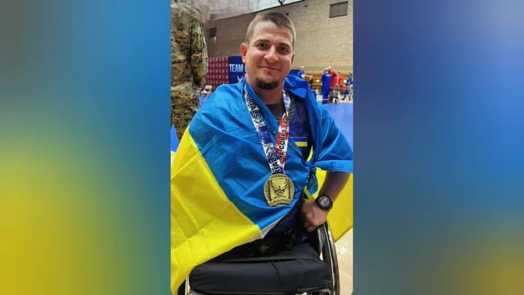 Український параспортсмен із медаллю та прапором України