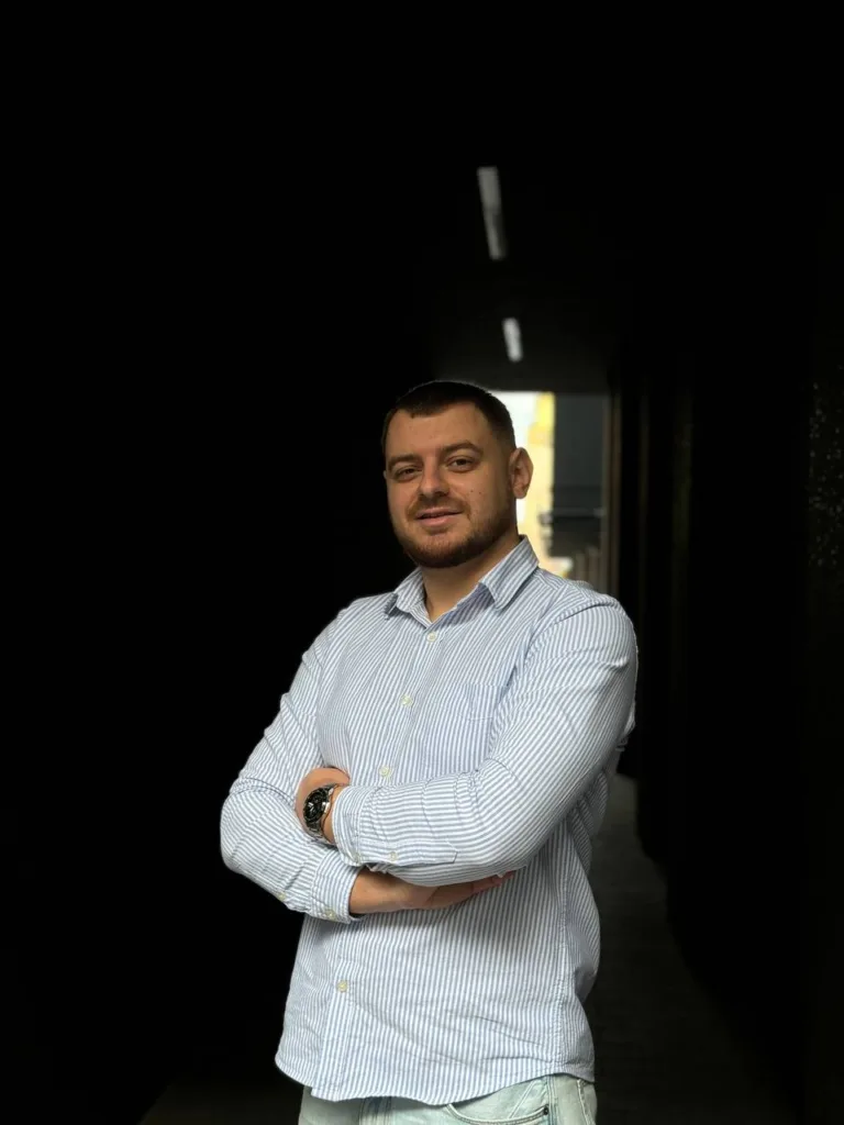 Чоловік у смугастій сорочці стоїть у проході