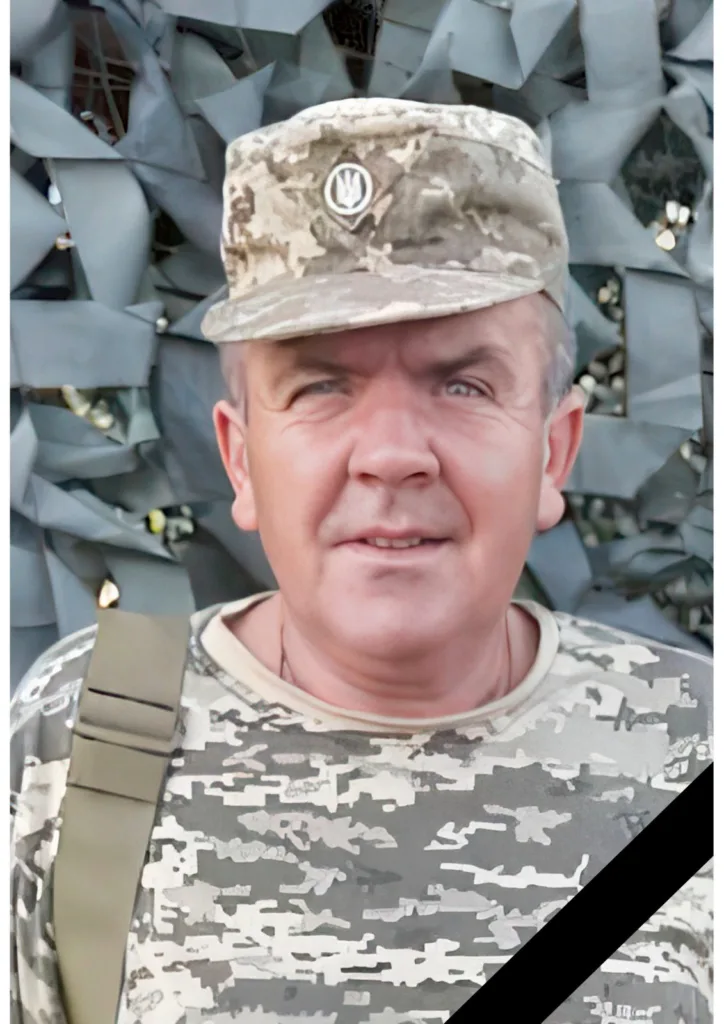 Український військовий у камуфляжі перед сіткою