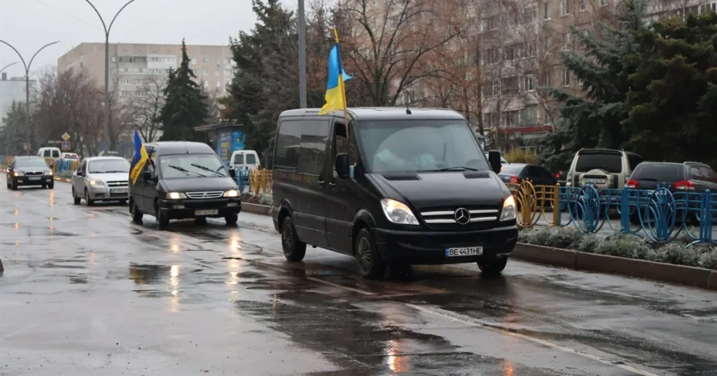 Автоколона з українськими прапорами на міській вулиці