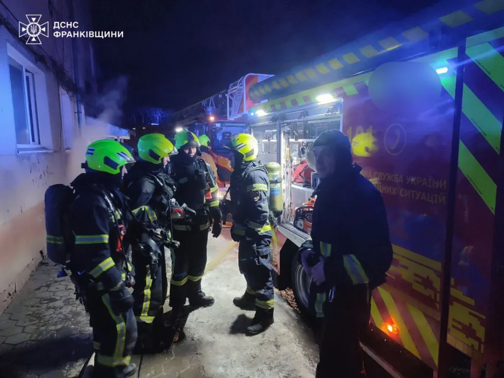 Пожежники біля пожежної машини вночі