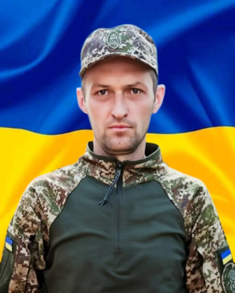 Український військовий перед прапором України