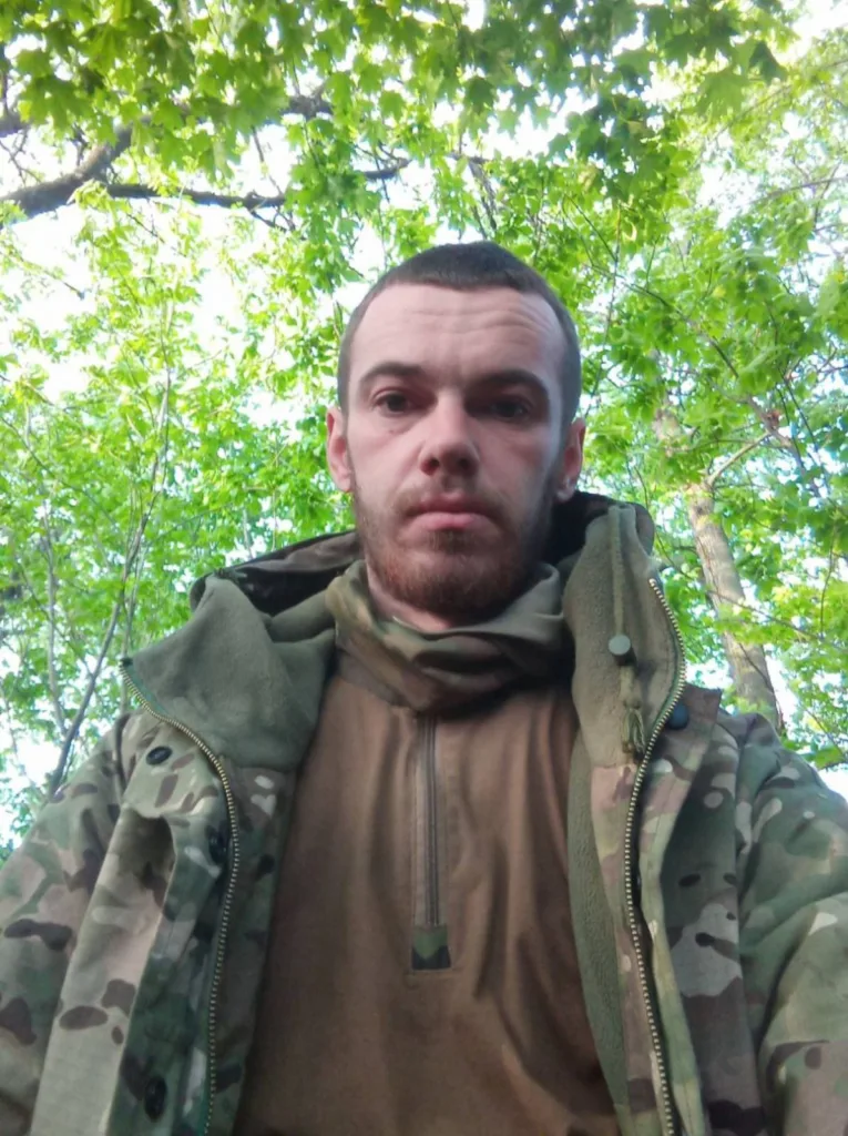 Чоловік у камуфляжі серед зеленого лісу