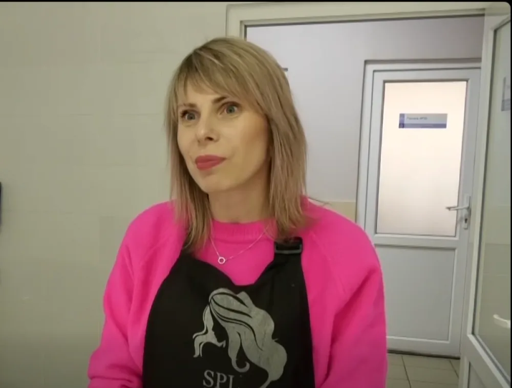 Жінка у рожевому светрі та фартуху в салоні