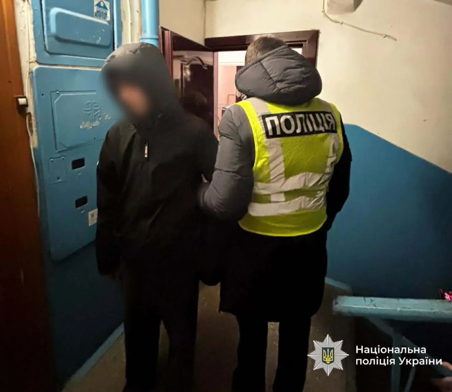 Поліцейський затримує підозрюваного в під'їзді будинку