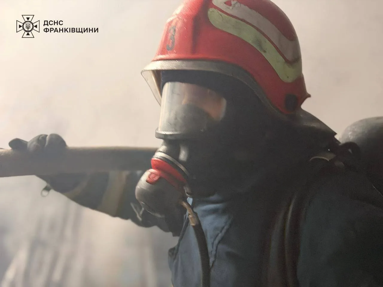 Пожежник у диму гасить пожежу