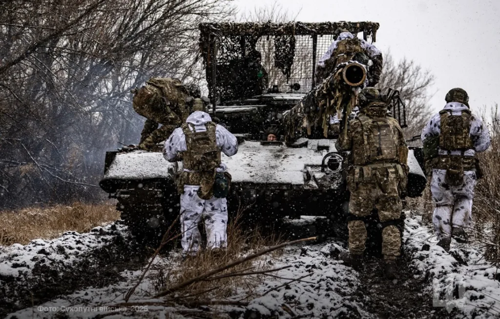 Військові біля бронетехніки у зимовому лісі