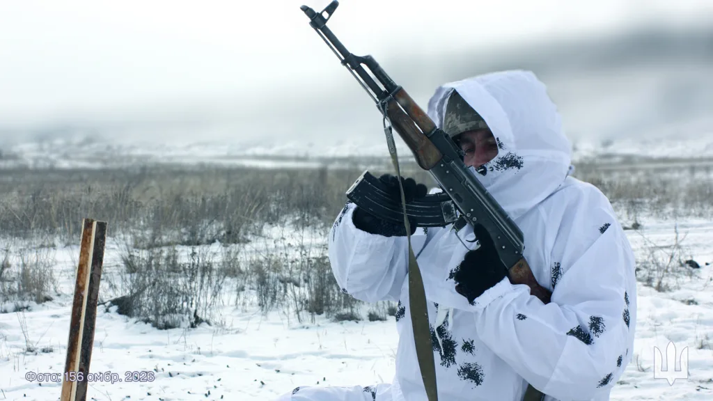 Військовий у зимовому камуфляжі тримає автомат