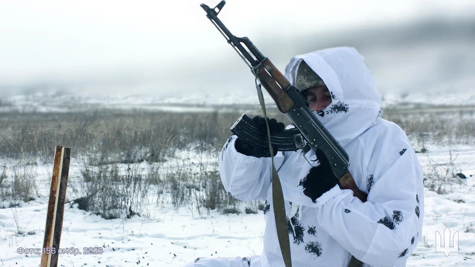 Військовий у зимовому камуфляжі тримає автомат