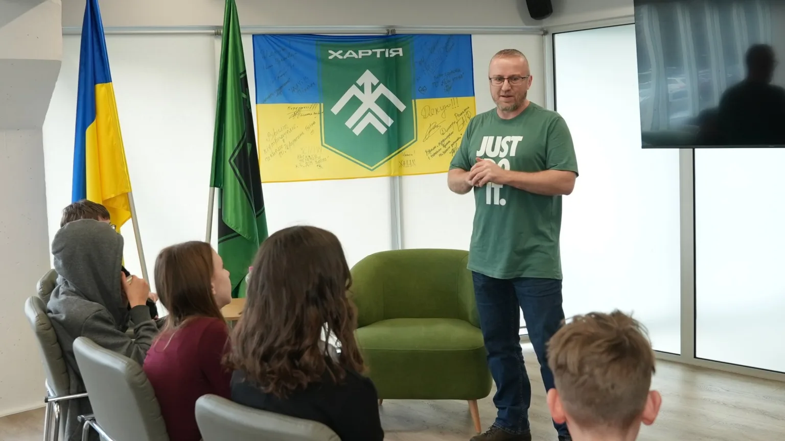 Лектор проводить заняття для студентів перед прапорами