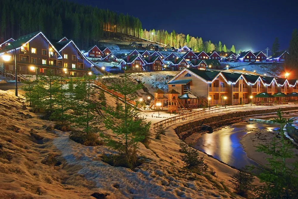 Зимовий гірський курорт з підсвіченими будинками вночі