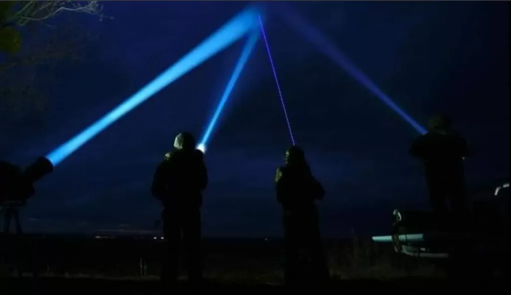 Люди з ліхтарями світять у нічне небо