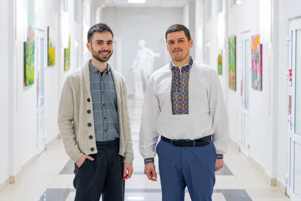 Двоє чоловіків стоять у світлому коридорі