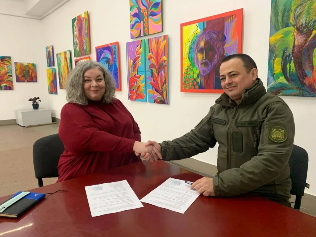 Люди потискають руки під час підписання документа