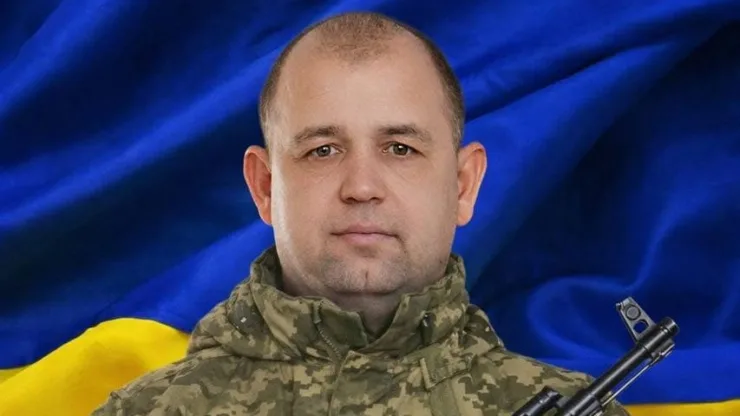 Український військовий на тлі прапора України