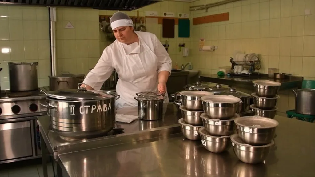Кухар працює на професійній кухні з каструлями