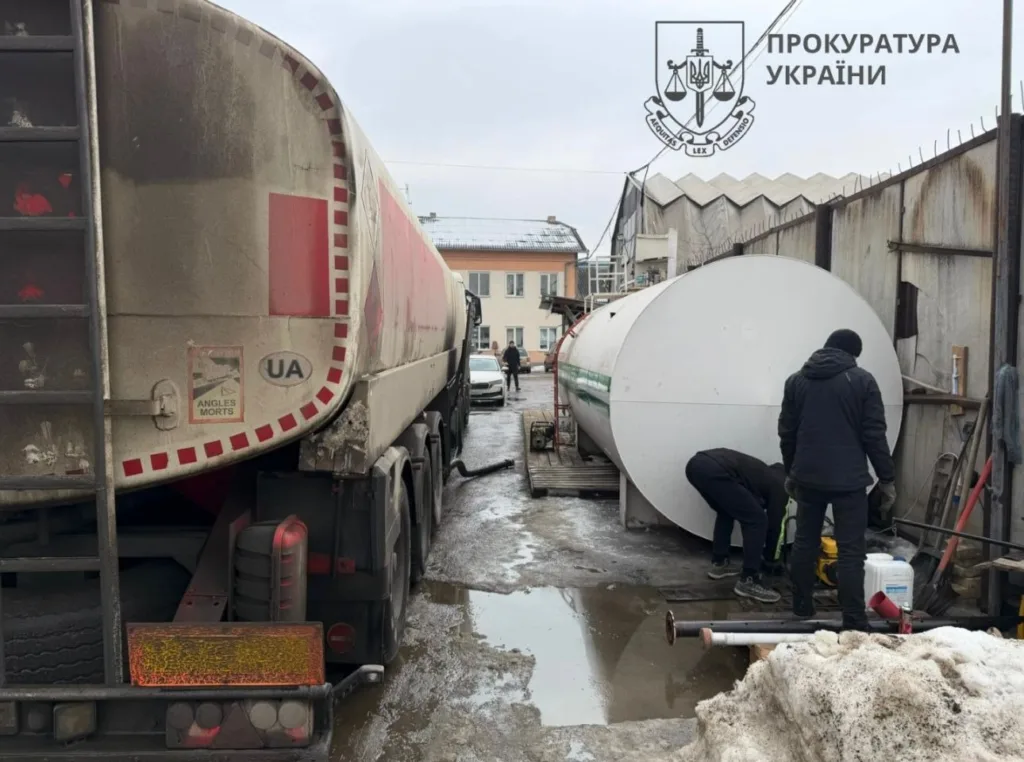 Паливна цистерна та працівники на промисловій території