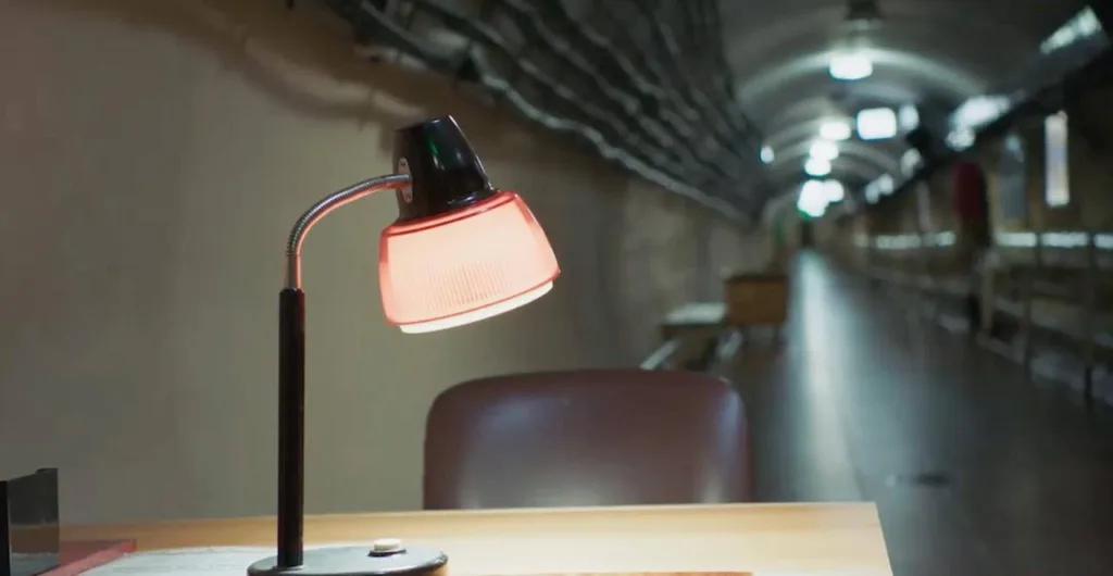 Настільна лампа на столі в підземному коридорі