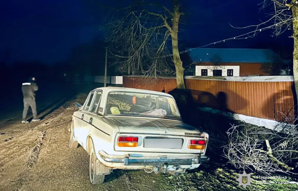 Поліцейський біля старого автомобіля вночі