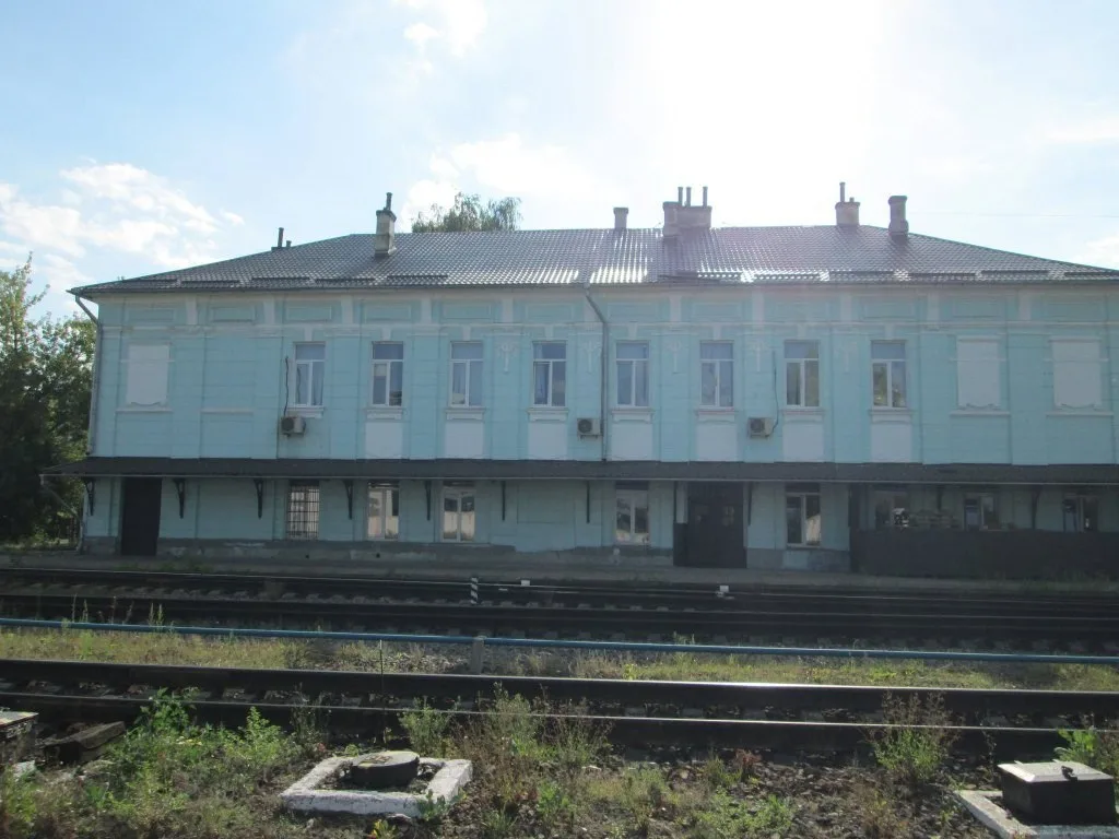 Стара будівля вокзалу біля залізничних колій