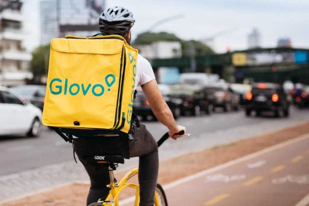 Кур'єр Glovo їде на велосипеді містом