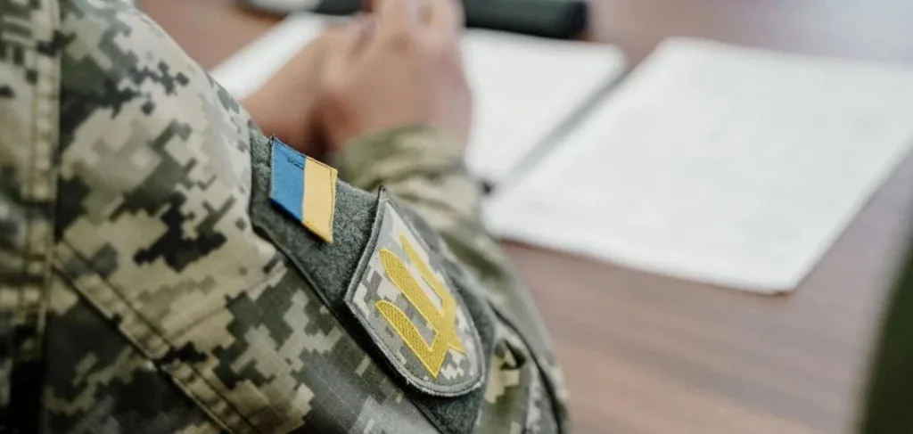 Український військовий у камуфляжі з прапором України