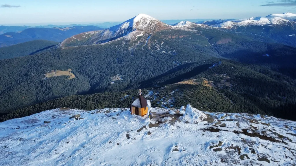 Засніжені Карпати з каплицею на вершині гори