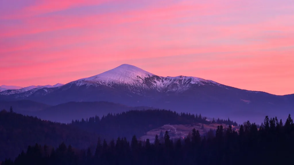 Захід сонця над засніженими Карпатськими горами