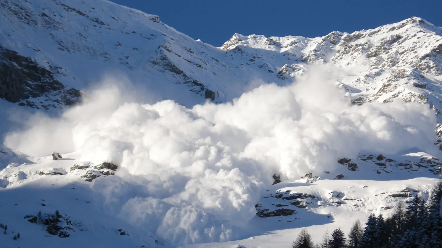 Снігова лавина сходить з гірських схилів