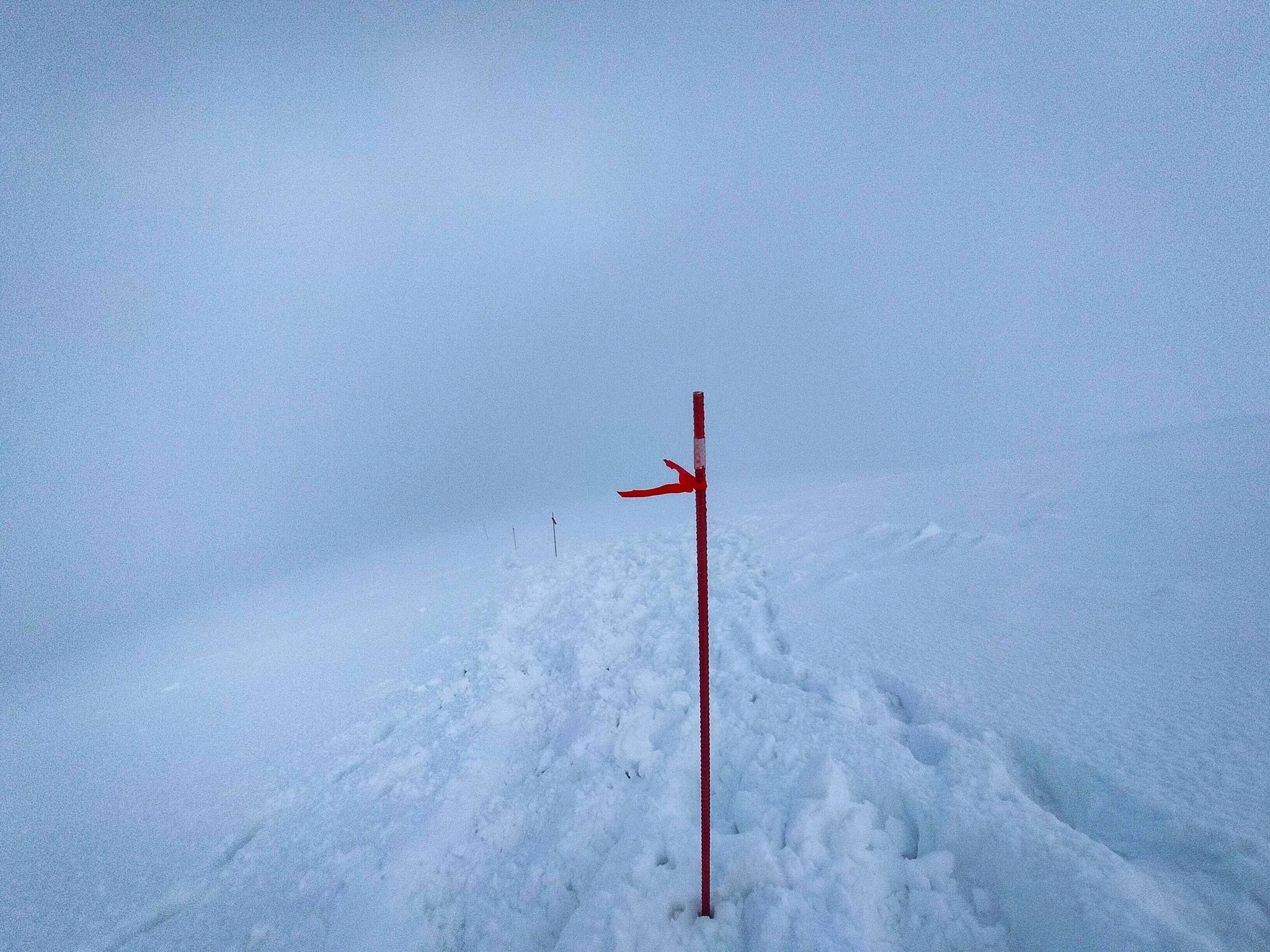 Червоні маркери на сніговій гірській стежці