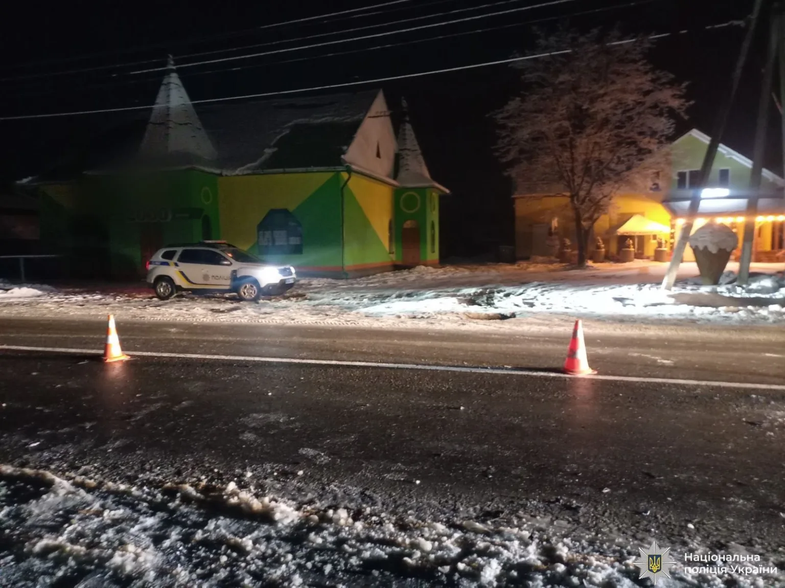 Поліцейський автомобіль на засніженій дорозі вночі