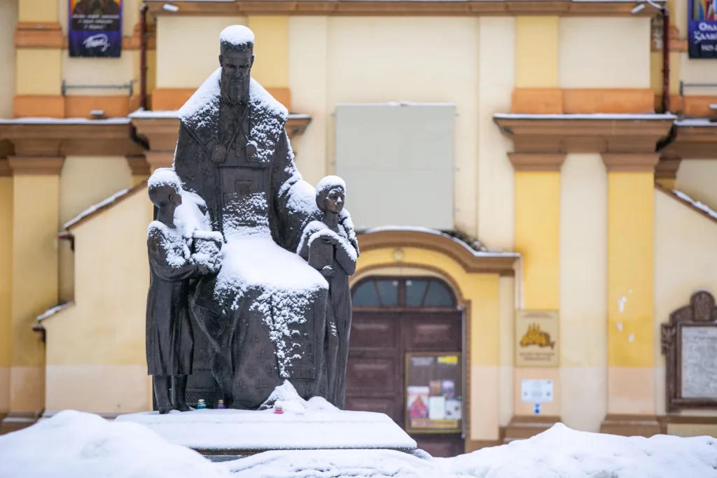 Пам'ятник у снігу перед старою будівлею