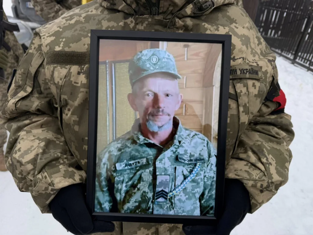 Військовий тримає фото загиблого солдата України