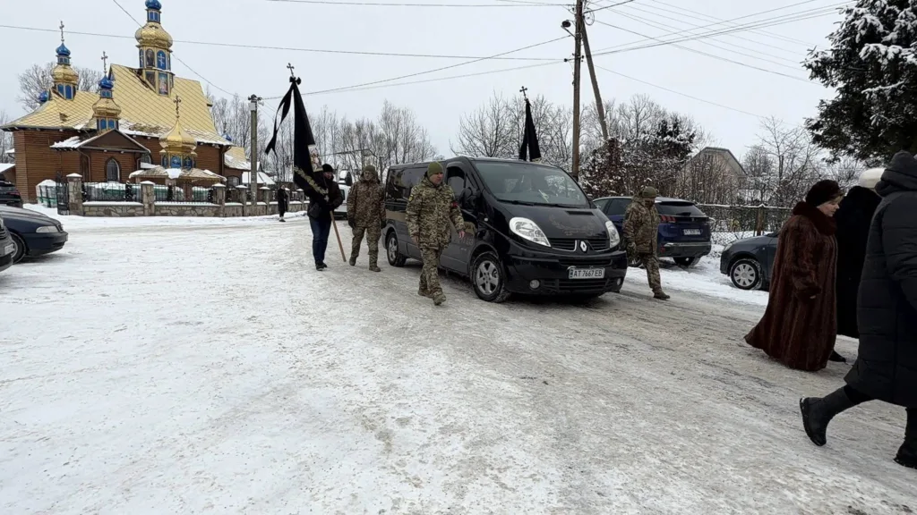 Похоронна процесія біля церкви взимку