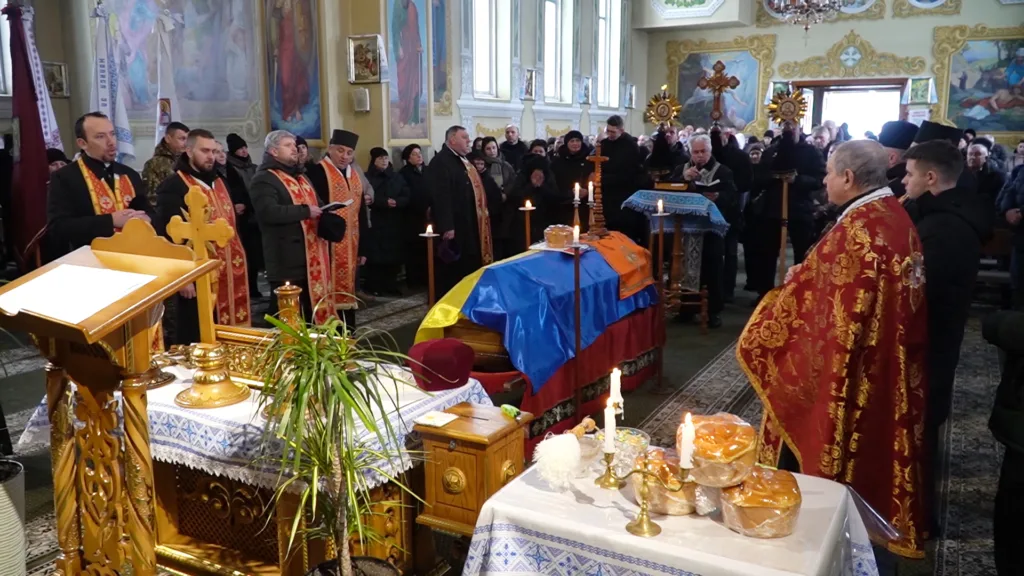 Похоронна служба в церкві з українським прапором