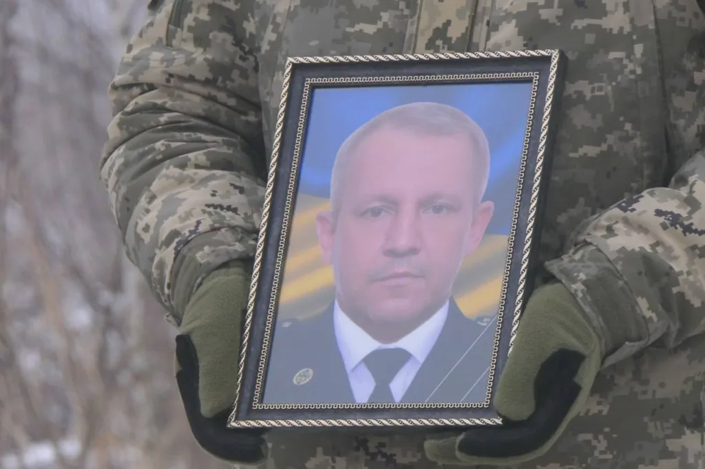 Військовий тримає портрет загиблого солдата