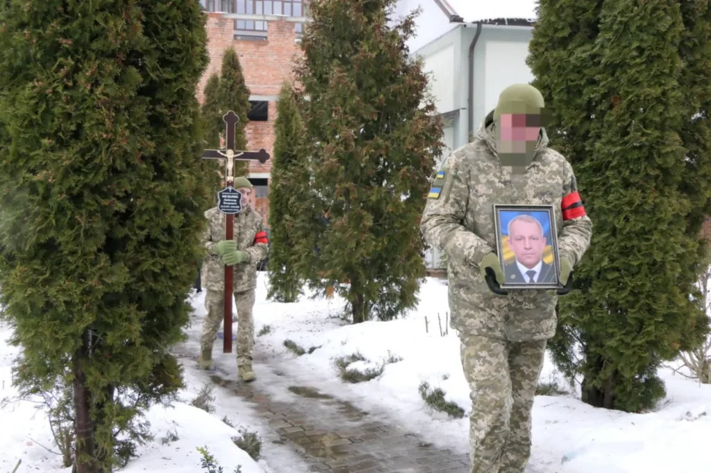 Військові несуть фото загиблого товариша на похороні