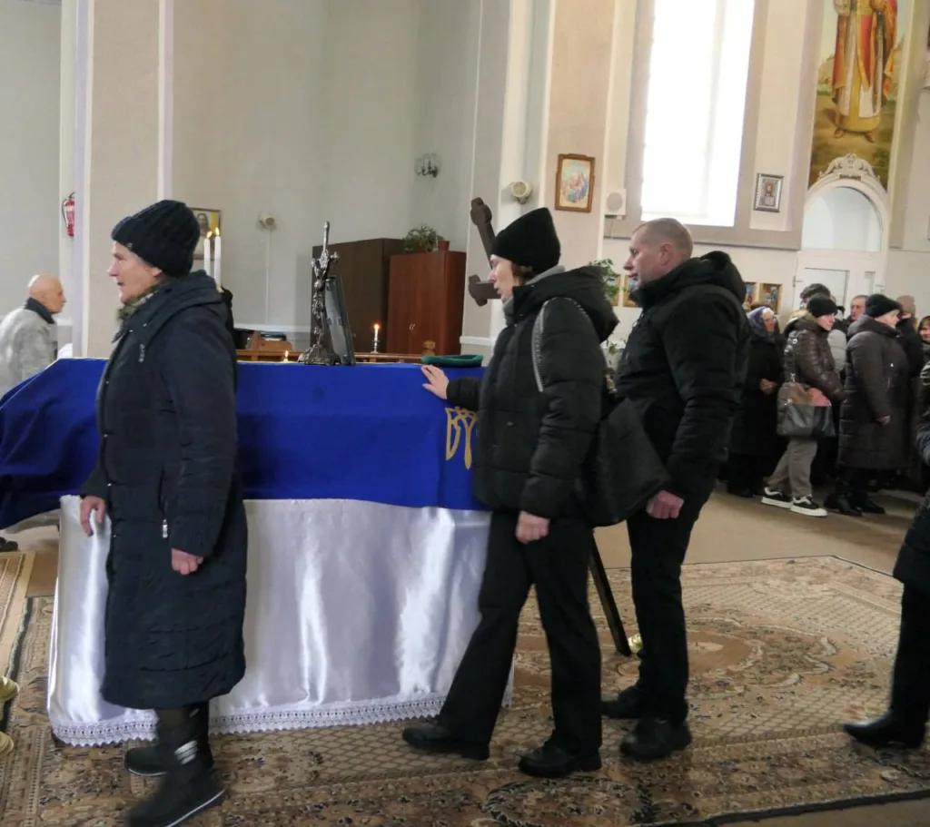 Люди прощаються з небіжчиком у церкві