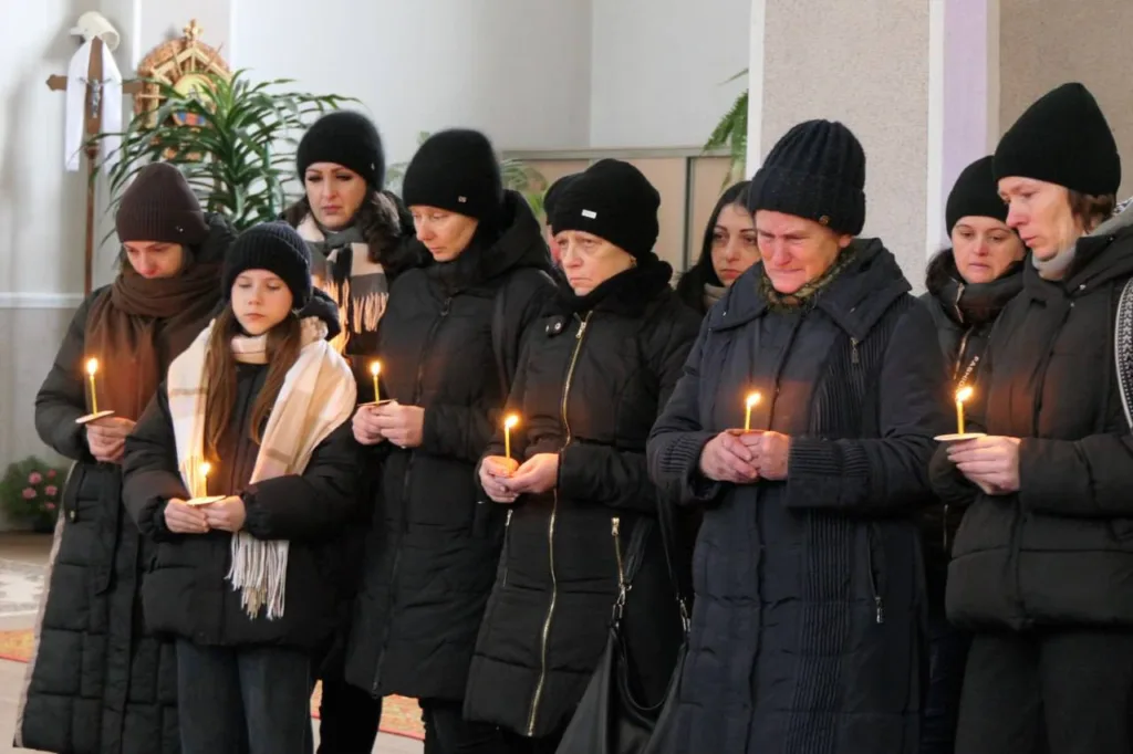 Люди тримають свічки під час поминальної молитви